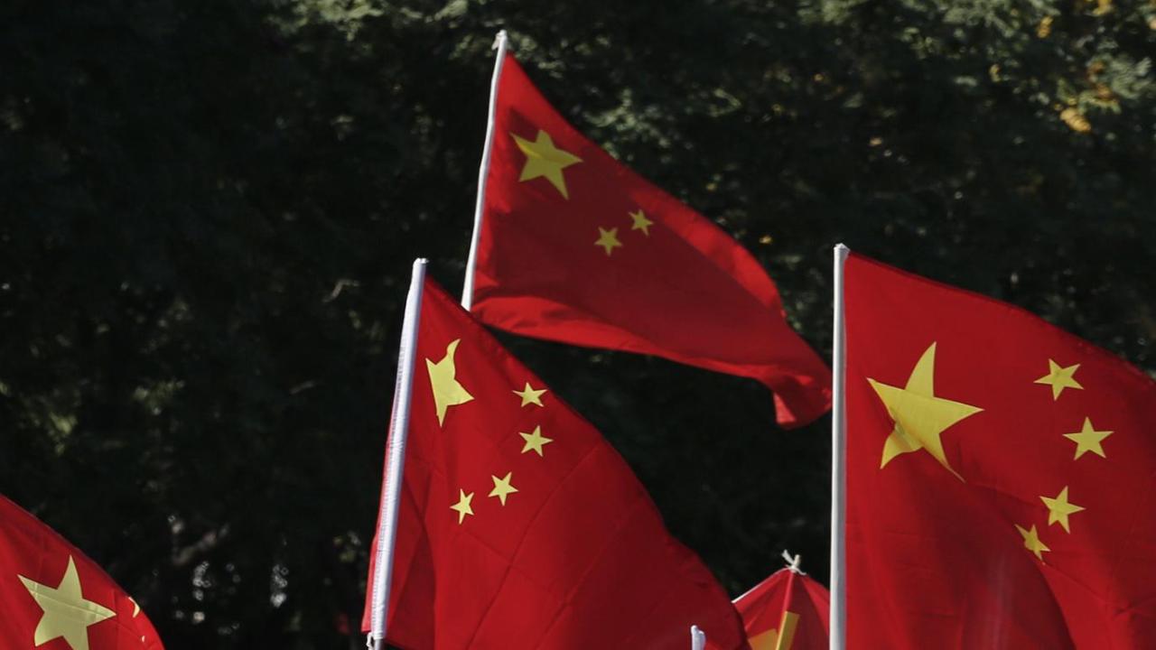 翻る中国の「紅い旗」（写真:ロイター/アフロ）