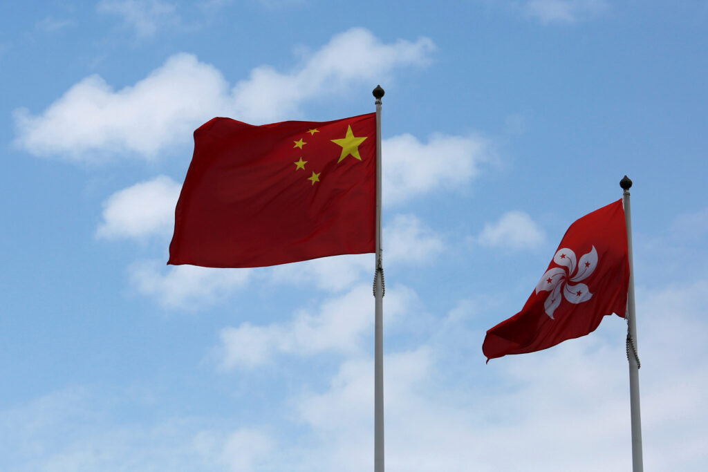 A Chinese national flag and a Hong Kong flag fly outside the Legislative Council in Hong Kong（写真：ロイター/アフロ）